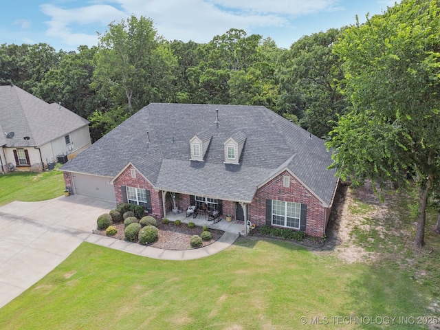 25070 S Red Oak Dr, Claremore, OK 74019 - view of front facade with brick siding, concrete driveway, an attached garage, a front lawn, and roof with shingles
