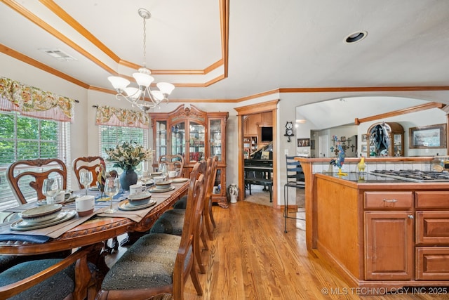 25070 S Red Oak Dr, Claremore, OK 74019 - dining area with a chandelier, arched walkways, light wood finished floors, a tray ceiling, and ornamental molding