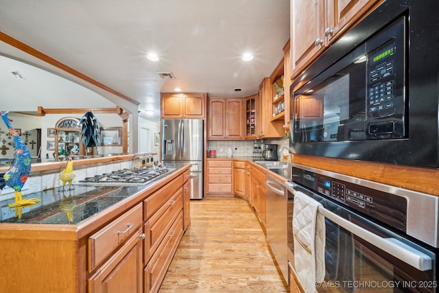 25070 S Red Oak Dr, Claremore, OK 74019 - kitchen featuring stainless steel appliances, light wood finished floors, glass insert cabinets, tile counters, and tasteful backsplash