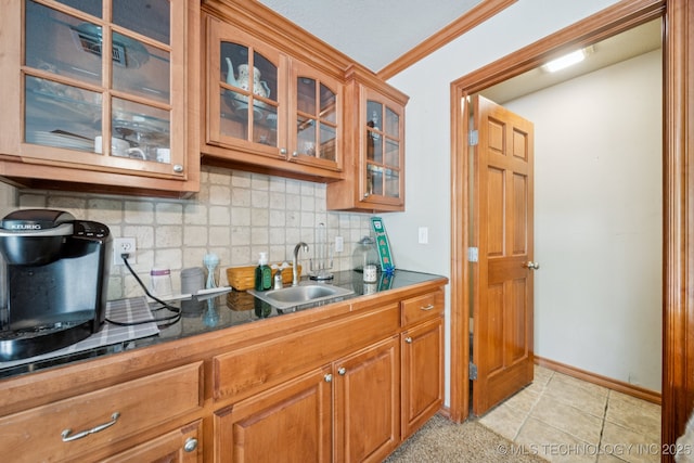 25070 S Red Oak Dr, Claremore, OK 74019 - kitchen with backsplash, glass insert cabinets, brown cabinetry, dark countertops, and light tile patterned flooring