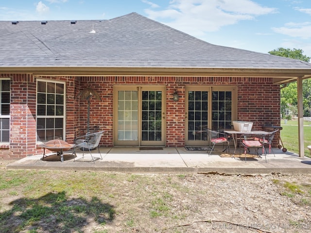 25070 S Red Oak Dr, Claremore, OK 74019 - back of house featuring a shingled roof, brick siding, a patio, and a fire pit