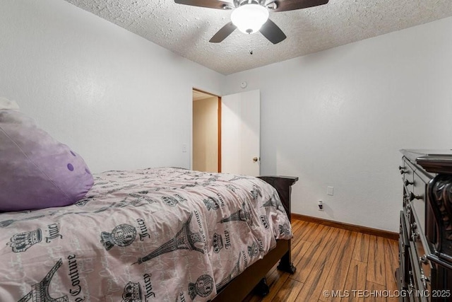 12915 S 120th E Pl, Tulsa, OK 74011 - bedroom with hardwood / wood-style floors, a textured ceiling, and ceiling fan