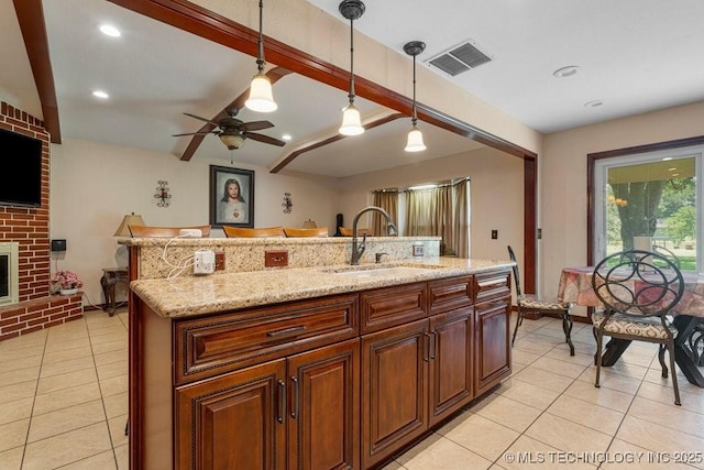 12915 S 120th E Pl, Tulsa, OK 74011 - kitchen with light tile patterned floors, pendant lighting, ceiling fan, an island with sink, and light stone counters