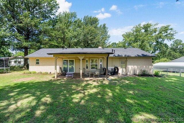 12915 S 120th E Pl, Tulsa, OK 74011 - back of house with a trampoline, brick siding, and a patio area