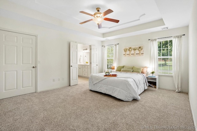 13718 S 262nd E Ave, Coweta, OK 74429 - bedroom with light colored carpet, a raised ceiling, multiple windows, and connected bathroom
