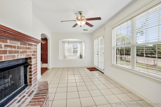 13718 S 262nd E Ave, Coweta, OK 74429 - unfurnished living room with ceiling fan, plenty of natural light, light tile patterned floors, and arched walkways