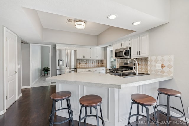 200 N Redwood Ct, Broken Arrow, OK 74012 - kitchen featuring stainless steel appliances, a peninsula, light countertops, and backsplash