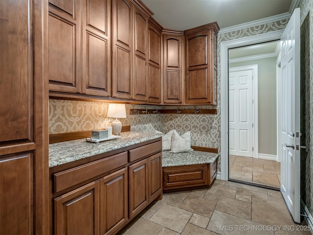 34159 E 698th Rd, Wagoner, OK 74467 - kitchen with stone tile flooring, ornamental molding, brown cabinets, and light stone counters