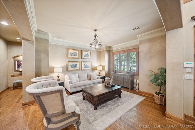 19735 E Woodhaven Rd, Owasso, OK 74055 - living area featuring light wood finished floors, ornamental molding, and a chandelier