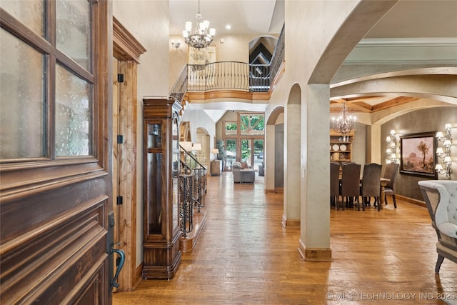19735 E Woodhaven Rd, Owasso, OK 74055 - foyer entrance featuring arched walkways, a chandelier, wood-type flooring, and stairs