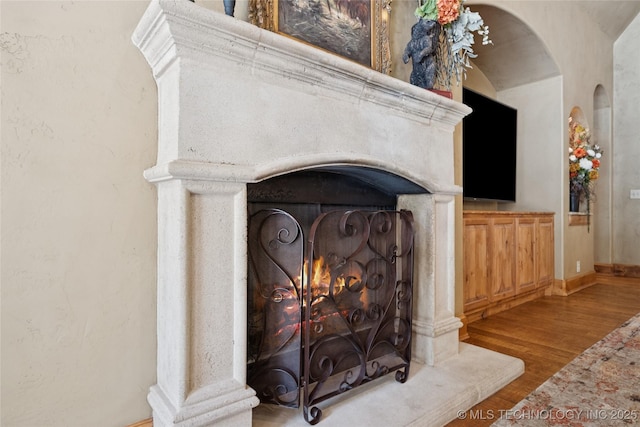 19735 E Woodhaven Rd, Owasso, OK 74055 - detailed view of arched walkways, wood finished floors, and a lit fireplace