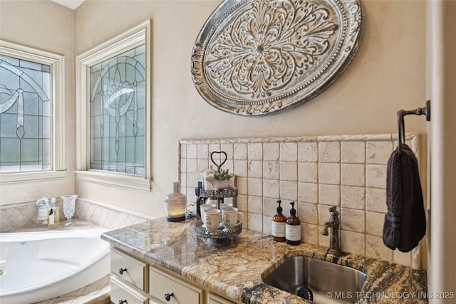 19735 E Woodhaven Rd, Owasso, OK 74055 - bathroom with a garden tub, vanity, and decorative backsplash