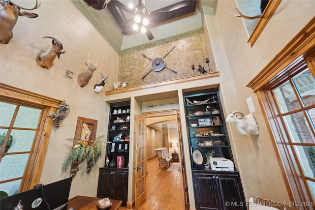 19735 E Woodhaven Rd, Owasso, OK 74055 - wine area with a high ceiling, ceiling fan, arched walkways, and wood finished floors