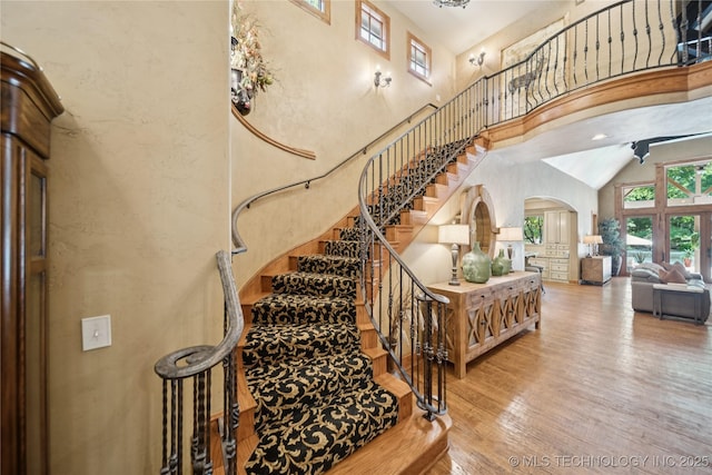 19735 E Woodhaven Rd, Owasso, OK 74055 - stairs with a towering ceiling, arched walkways, and wood finished floors