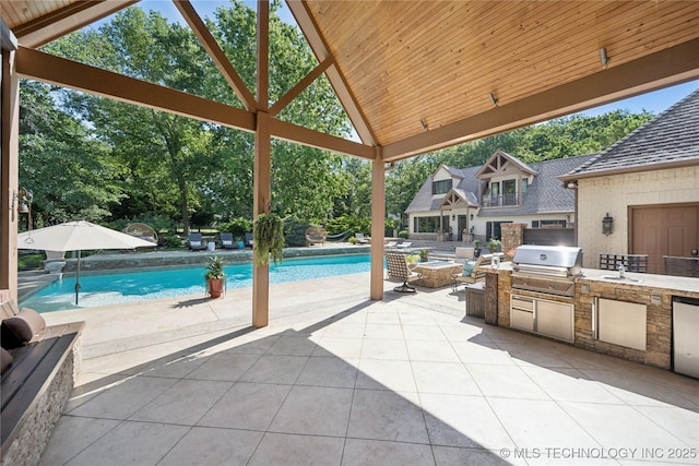 19735 E Woodhaven Rd, Owasso, OK 74055 - view of patio / terrace featuring an outdoor kitchen, an outdoor pool, a gazebo, and view of scattered trees