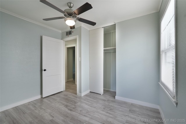 6240 E Latimer Pl, Tulsa, OK 74115 - unfurnished bedroom featuring multiple windows, light wood finished floors, a closet, and crown molding