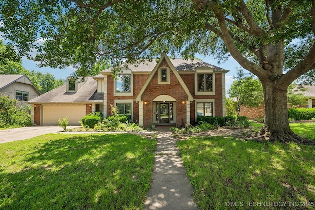 7222 E 87th St, Tulsa, OK 74133 - english style home featuring brick siding, a garage, a front lawn, and driveway