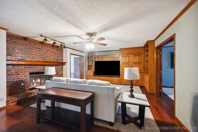 7222 E 87th St, Tulsa, OK 74133 - living room with ornamental molding, a textured ceiling, track lighting, dark wood finished floors, and a brick fireplace
