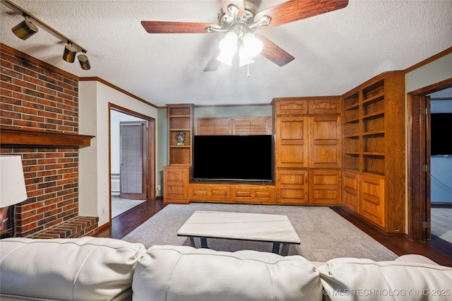 7222 E 87th St, Tulsa, OK 74133 - living area featuring a textured ceiling, ceiling fan, crown molding, wood finished floors, and a brick fireplace
