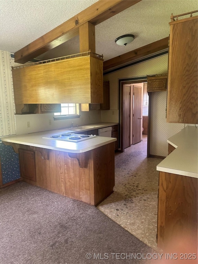 282 Westland Rd, Sapulpa, OK 74066 - kitchen featuring wallpapered walls, a textured ceiling, a peninsula, brown cabinetry, and light countertops