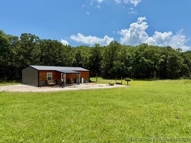 105148 S 4500, Vian, OK 74962 - view of grassy yard with a forest view and an outbuilding
