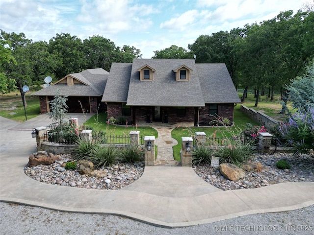 6166 Hedges St, Ardmore, OK 73401 - view of front of house featuring a porch, brick siding, roof with shingles, and a fenced front yard