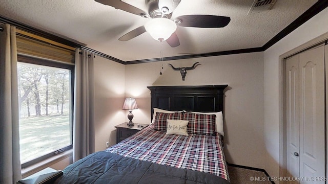 6166 Hedges St, Ardmore, OK 73401 - carpeted bedroom featuring a textured ceiling, crown molding, ceiling fan, and a closet