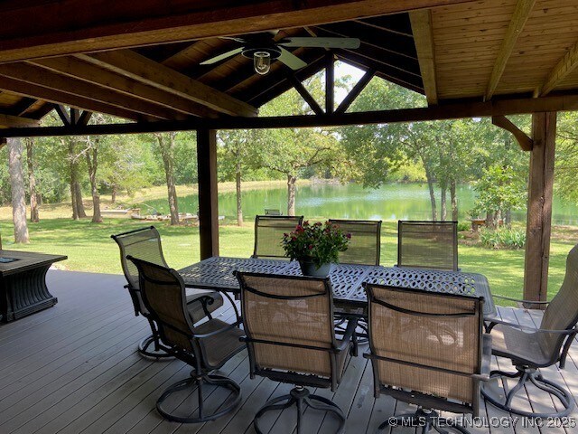 6166 Hedges St, Ardmore, OK 73401 - deck featuring ceiling fan, a water view, outdoor dining space, a yard, and a gazebo