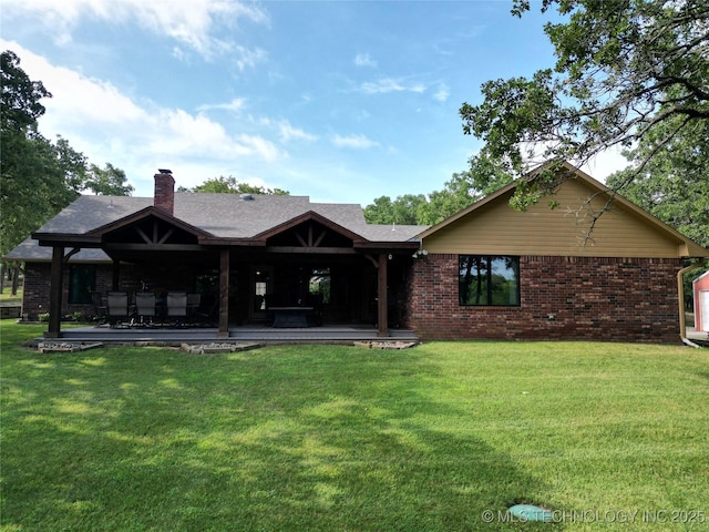 6166 Hedges St, Ardmore, OK 73401 - back of house featuring a yard, brick siding, a chimney, and a patio area