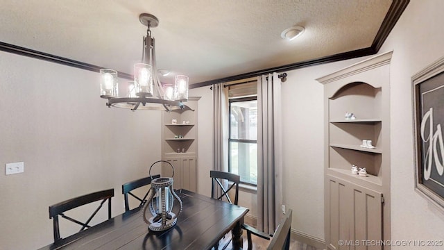 6166 Hedges St, Ardmore, OK 73401 - dining area with crown molding, built in shelves, a chandelier, a textured ceiling, and wood finished floors