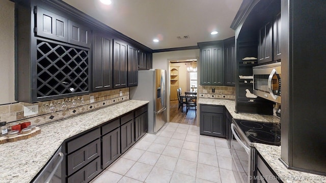 6166 Hedges St, Ardmore, OK 73401 - kitchen featuring stainless steel appliances, crown molding, tasteful backsplash, light tile patterned floors, and light stone counters
