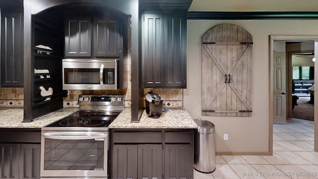 6166 Hedges St, Ardmore, OK 73401 - kitchen with stainless steel appliances, backsplash, light tile patterned flooring, and light stone countertops