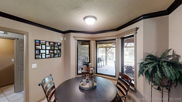 6166 Hedges St, Ardmore, OK 73401 - dining room featuring ornamental molding, a textured ceiling, and light tile patterned floors