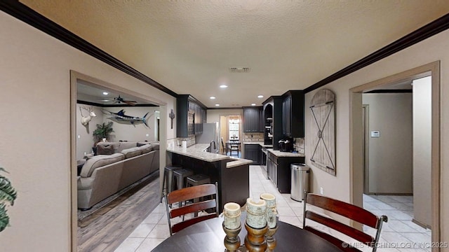 6166 Hedges St, Ardmore, OK 73401 - dining space featuring crown molding, light tile patterned flooring, a textured ceiling, and recessed lighting