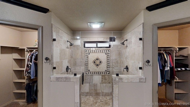 6166 Hedges St, Ardmore, OK 73401 - full bathroom featuring a walk in closet, a stall shower, and a textured ceiling