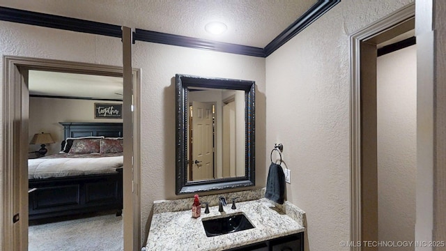 6166 Hedges St, Ardmore, OK 73401 - ensuite bathroom with a textured wall, crown molding, vanity, and a textured ceiling