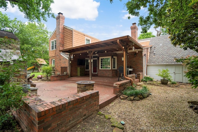 213 Moccasin Ln, Sapulpa, OK 74066 - back of property featuring a patio, a fire pit, brick siding, and a chimney