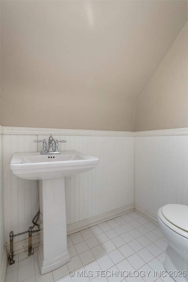 213 Moccasin Ln, Sapulpa, OK 74066 - half bath with a wainscoted wall, lofted ceiling, and tile patterned floors