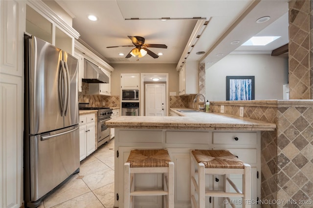 213 Moccasin Ln, Sapulpa, OK 74066 - kitchen with appliances with stainless steel finishes, tile walls, a peninsula, crown molding, and wall chimney exhaust hood
