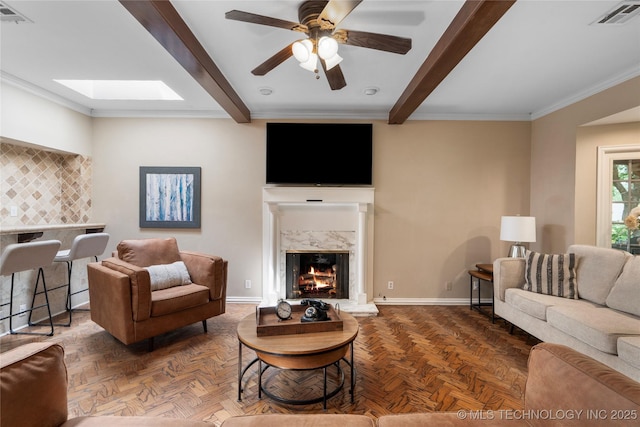 213 Moccasin Ln, Sapulpa, OK 74066 - living area with beam ceiling, a premium fireplace, a ceiling fan, and crown molding