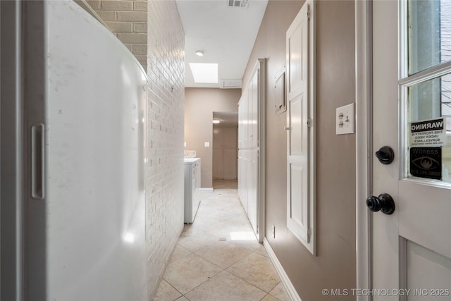 213 Moccasin Ln, Sapulpa, OK 74066 - corridor with light tile patterned floors, a skylight, and washer / dryer