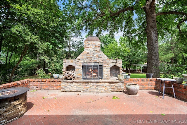 213 Moccasin Ln, Sapulpa, OK 74066 - view of patio featuring an outdoor stone fireplace and a fire pit