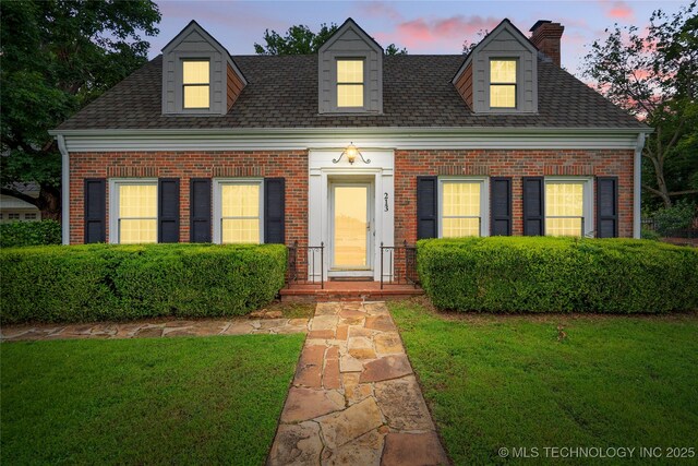 213 Moccasin Ln, Sapulpa, OK 74066 - cape cod house with brick siding, a front yard, a chimney, and roof with shingles