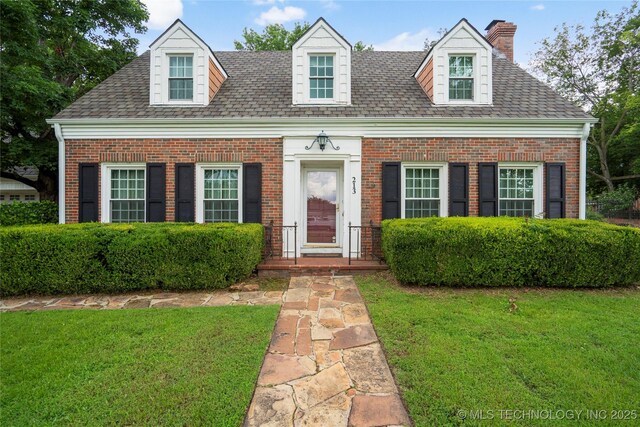 213 Moccasin Ln, Sapulpa, OK 74066 - cape cod house with brick siding, a front yard, a chimney, and roof with shingles