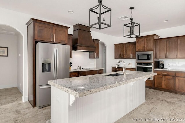8337 N 149th E Ave, Owasso, OK 74055 - kitchen with appliances with stainless steel finishes, arched walkways, custom range hood, tasteful backsplash, and recessed lighting