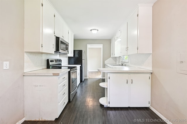 1422 E 52nd St, Tulsa, OK 74105 - kitchen with stainless steel appliances, light countertops, dark wood finished floors, and white cabinets
