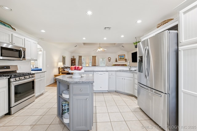 1014 W 120th St S, Jenks, OK 74037 - kitchen featuring stainless steel appliances, open floor plan, light tile patterned floors, white cabinets, and a peninsula