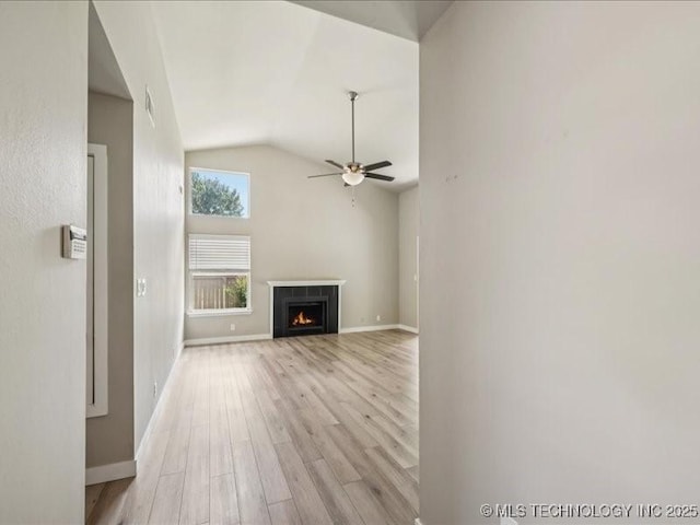 9118 S Florence Ave Unit 9118, Tulsa, OK 74137 - unfurnished living room featuring light wood-type flooring, vaulted ceiling, a warm lit fireplace, and a ceiling fan