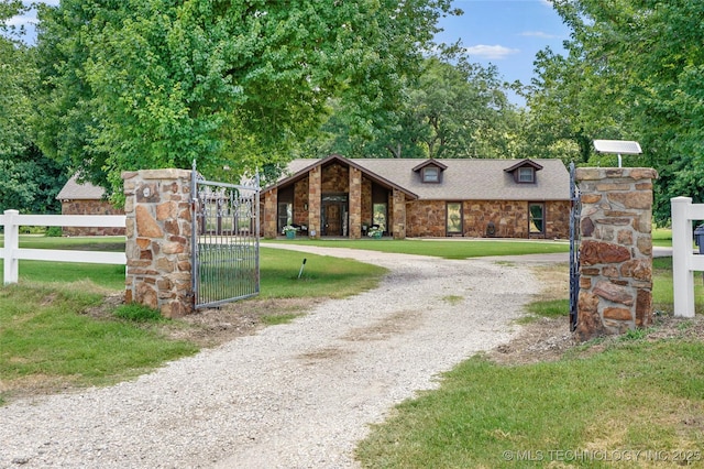 18251 145th W Ave, Sapulpa, OK 74066 - mid-century home with curved driveway, stone siding, a gate, and roof with shingles