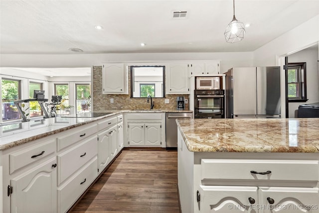 18251 145th W Ave, Sapulpa, OK 74066 - kitchen with black appliances, white cabinets, light stone counters, decorative backsplash, and a peninsula
